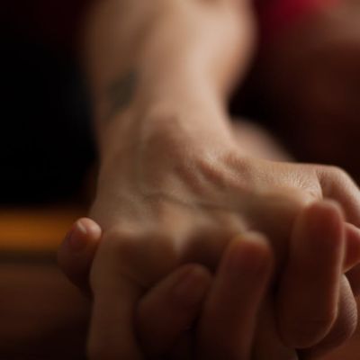 A close-up shot of two hands clasped together on a wooden surface, conveying intimacy and connection.